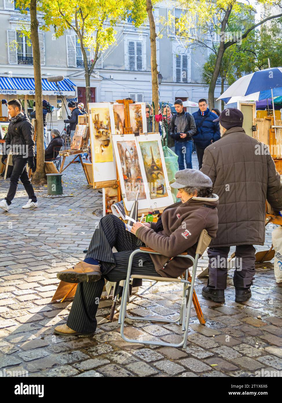 Artists at work painting and displaying pictures for sale in Place du Tertre, Montmartre, 18th arrondissement, Paris, France Stock Photo