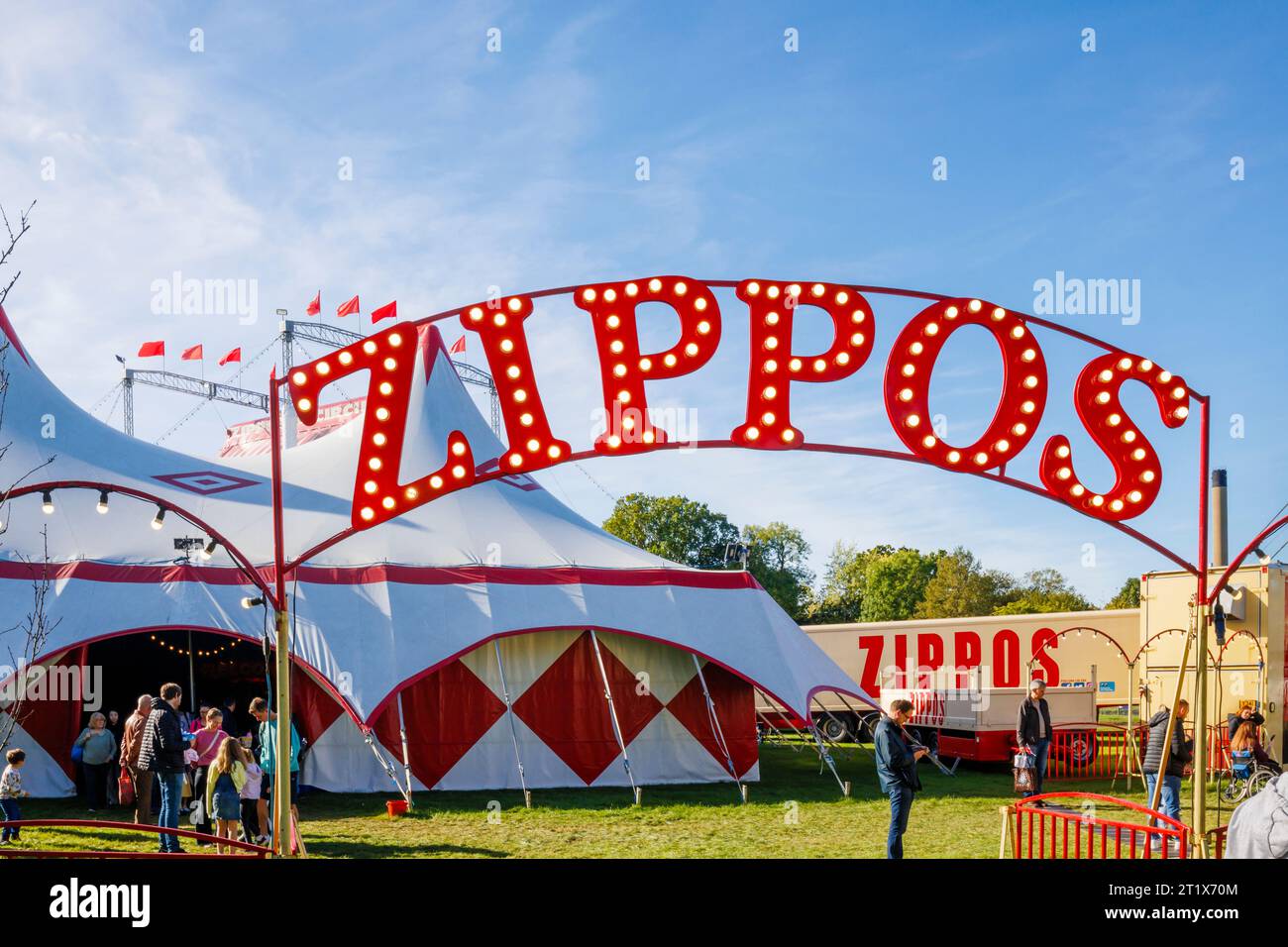 The illuminated name sign at the entrance to Zippos Circus in Guildford on a sunny day with blue sky Stock Photo