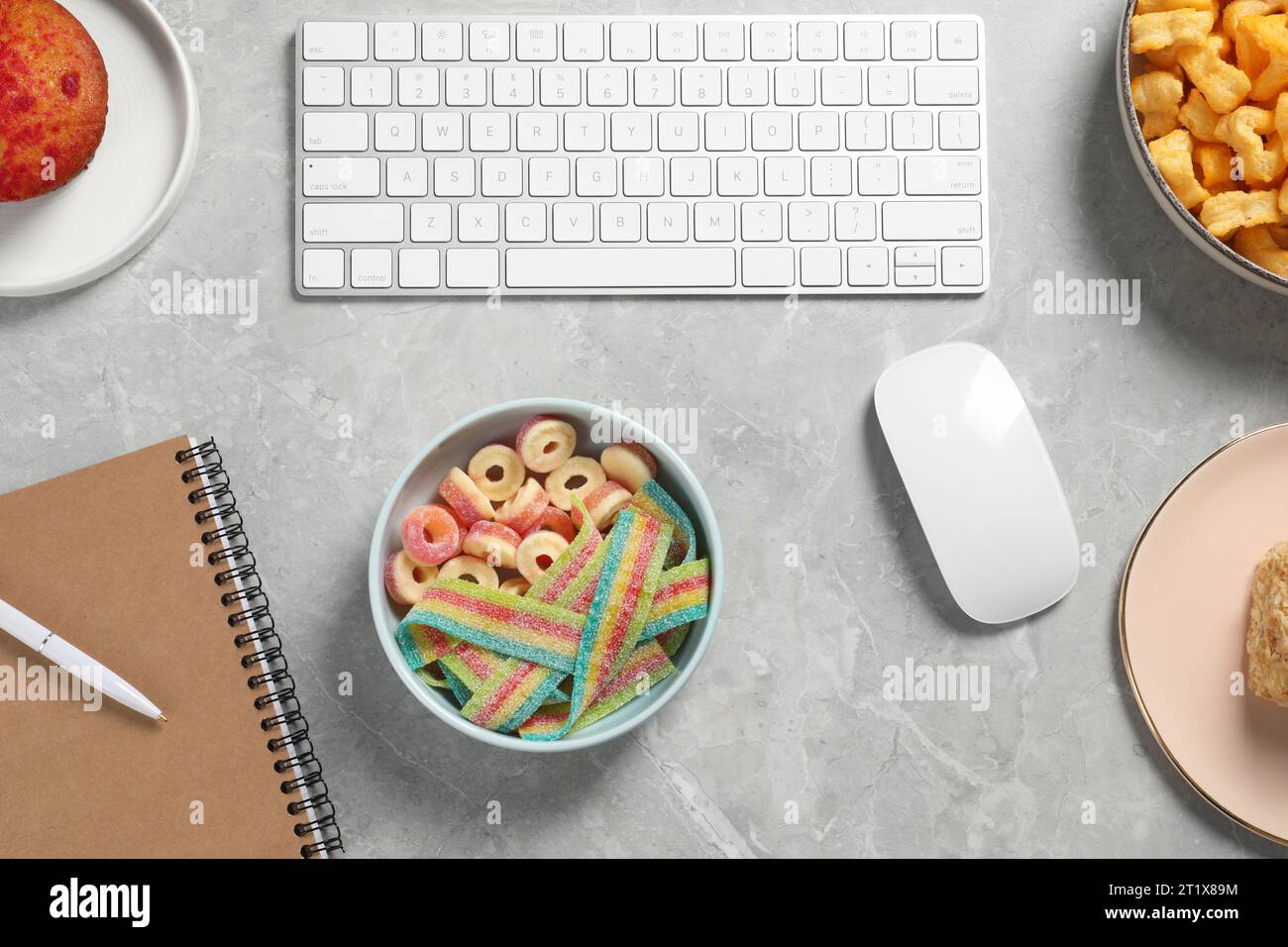 Bad eating habits at workplace. White keyboard, mouse and different ...