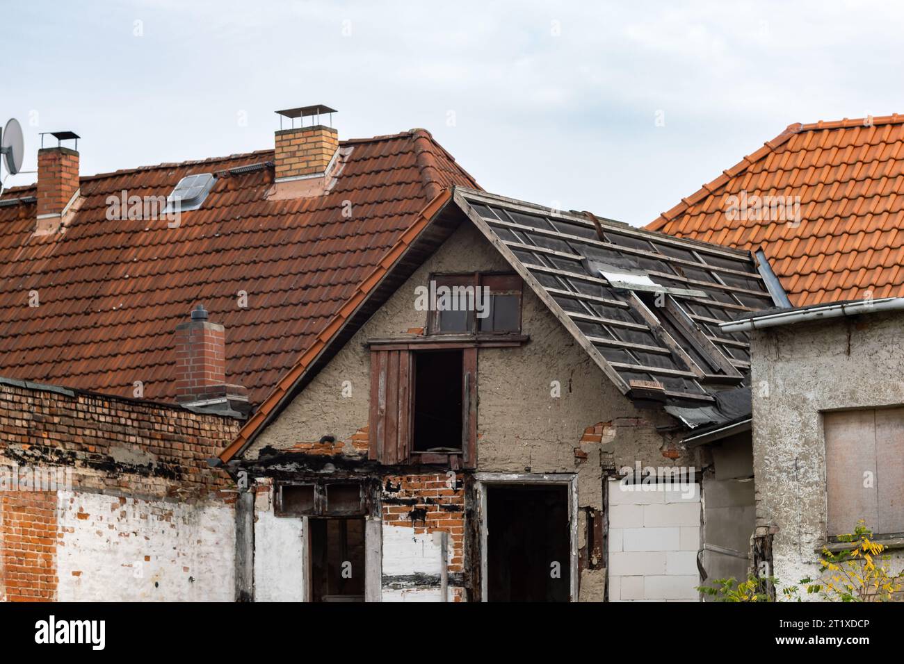 Ruined building in a German town. The abandoned house is very old and in bad condition. The windows and doors are damaged. The building is weak. Stock Photo