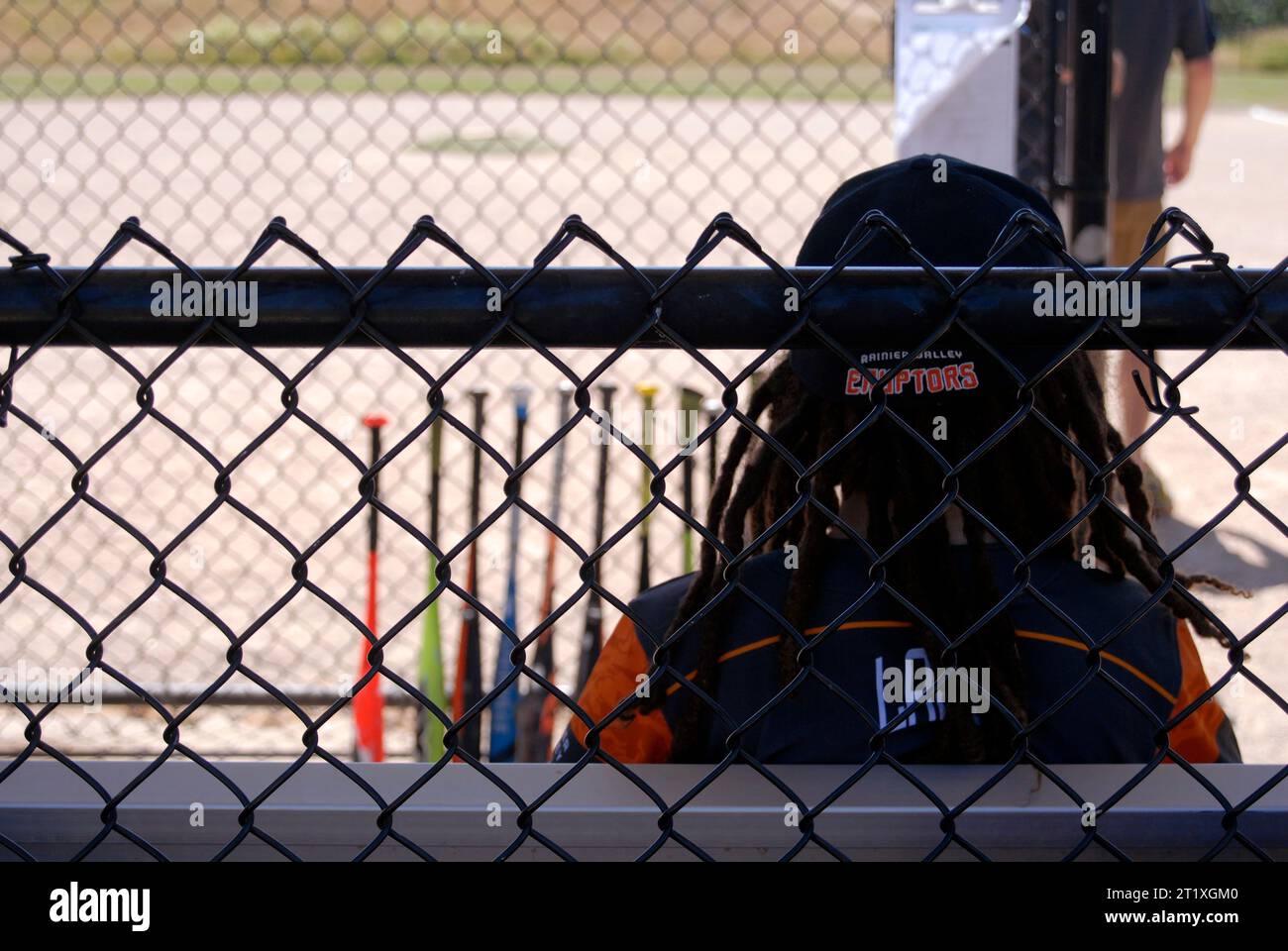 Little league baseball player sitting in dugout Stock Photo Alamy