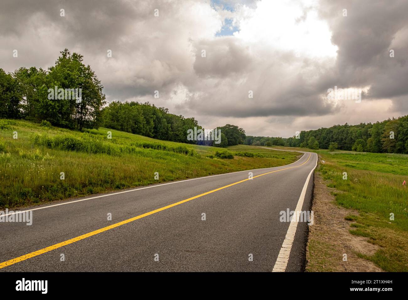 Storm clouds hover over the road in rural Templeton, Massachusetts Stock Photo