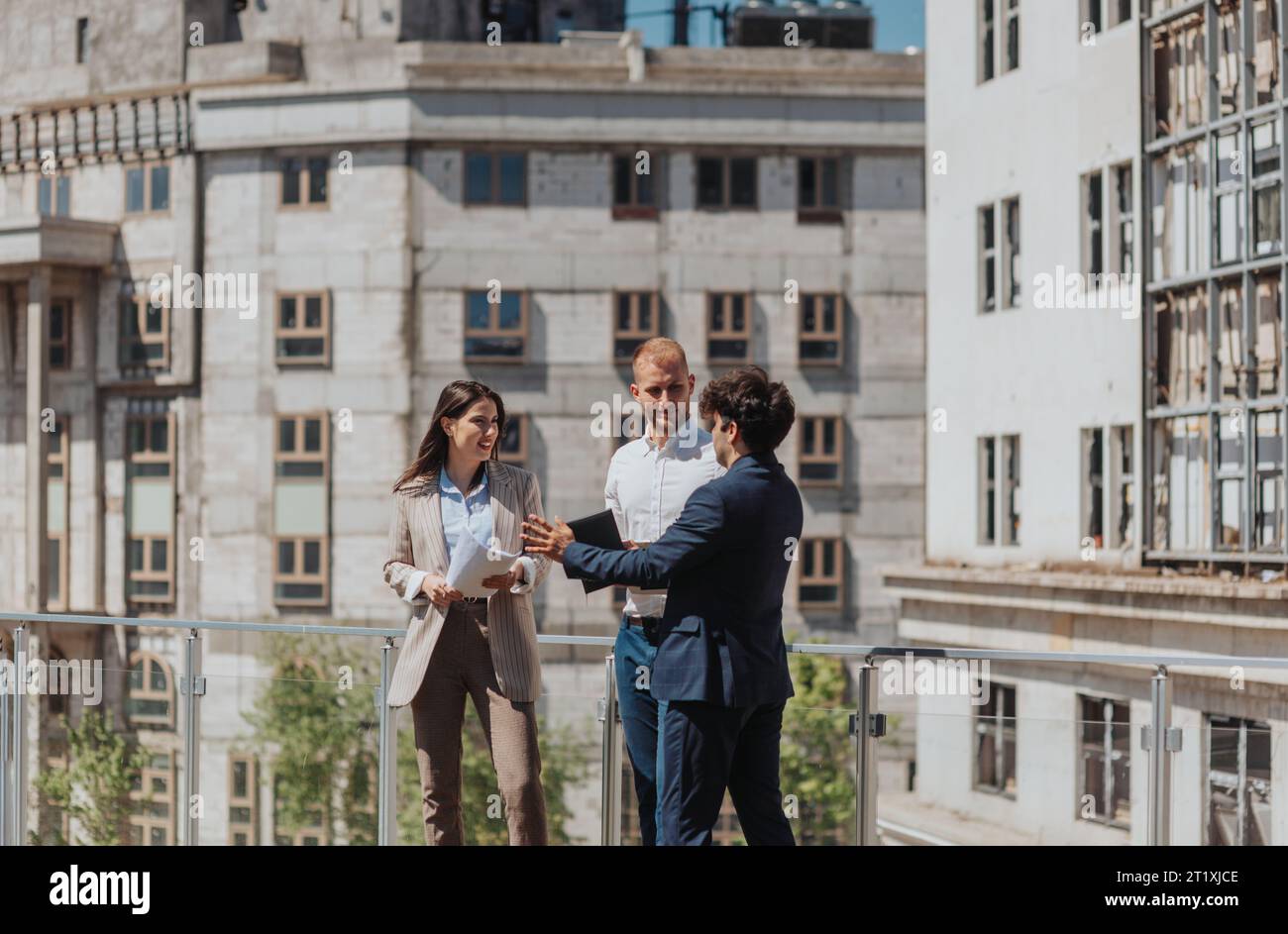 Young construction engineers discussing project while standing on a construction site in the city Stock Photo
