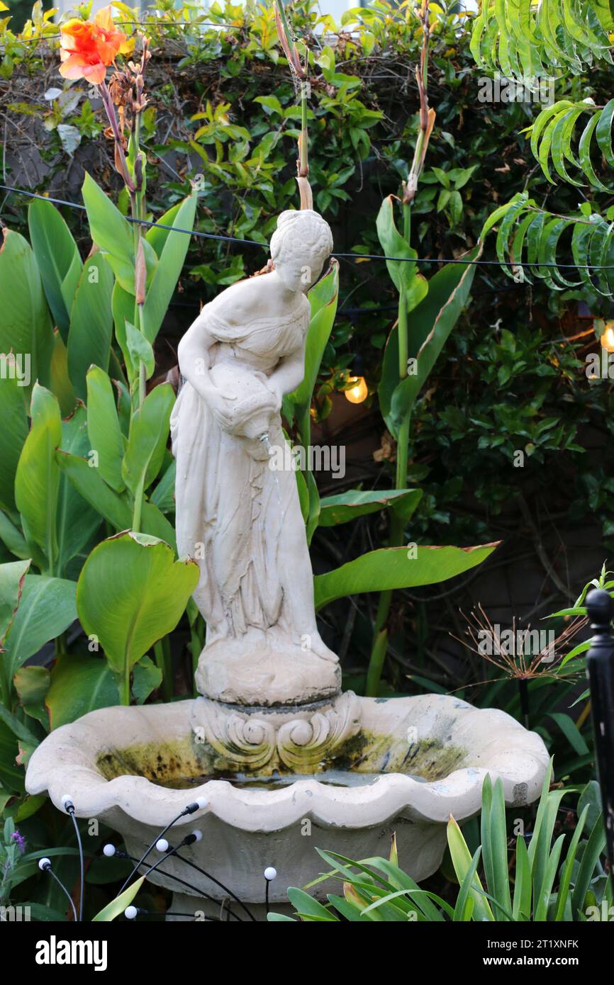 Beautiful statue of a woman pouring water from a vase into a fountain