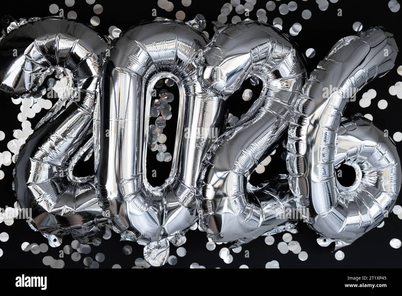 Happy new year 2026 metallic balloons with confetti on dark black