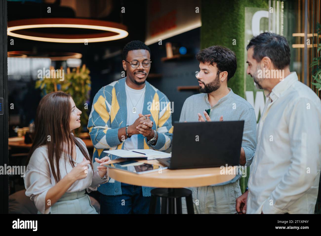 Multiracial business team collaborates on projects, discussing ideas and sharing knowledge for efficient work outcomes. Stock Photo