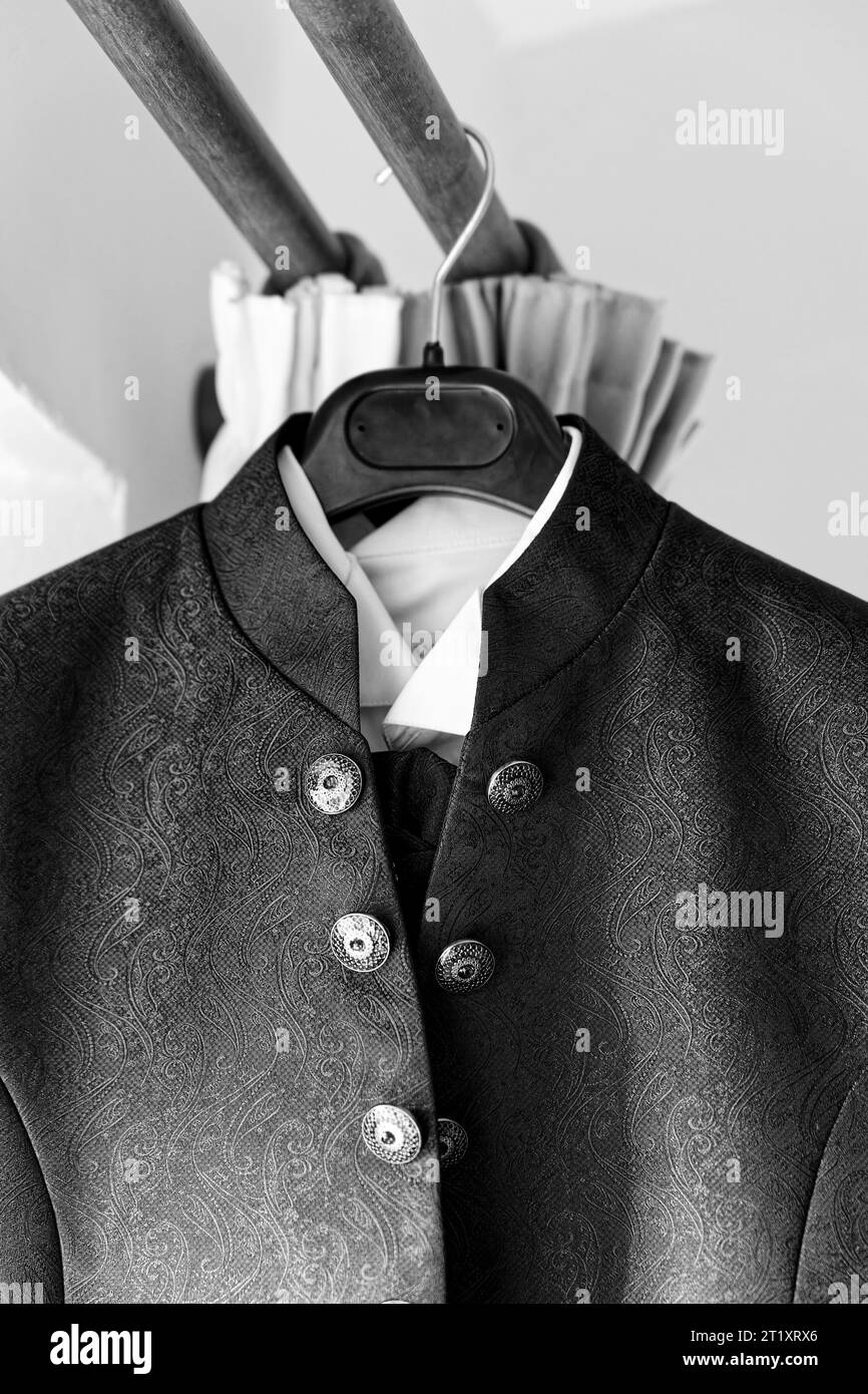 A grayscale of a groom's wedding jacket on a hanger Stock Photo