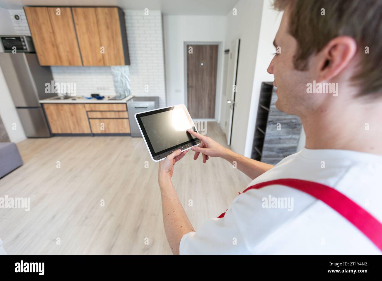 Worker with tablet computer checking alarm system indoors. Stock Photo