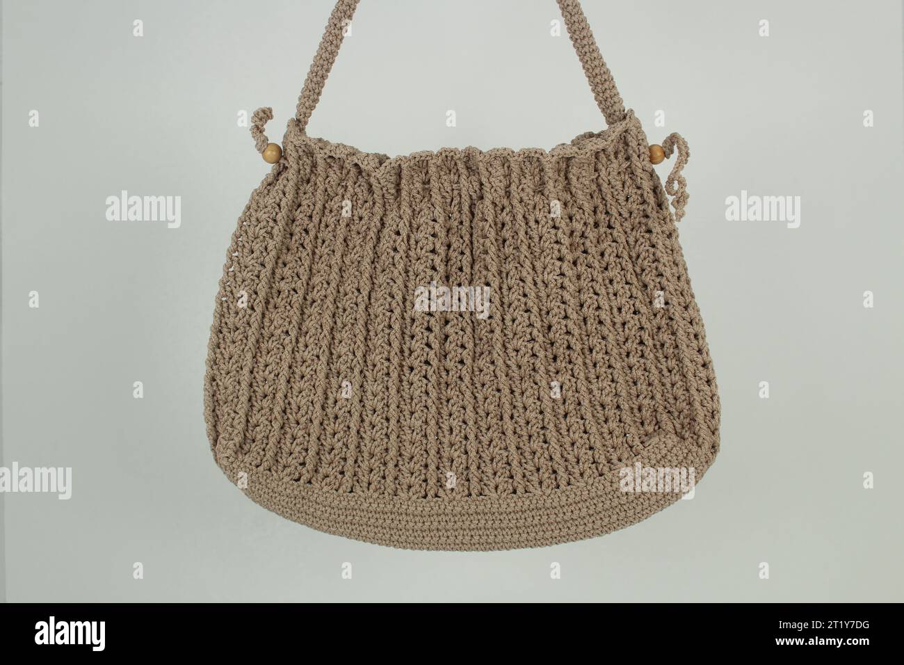 Knitted handmade milky brown bag isolated on white background. Stock Photo