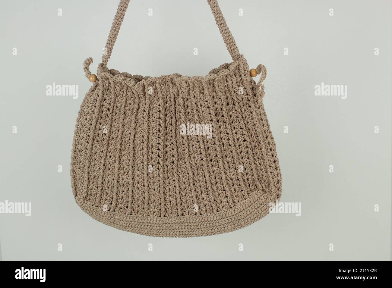 Knitted handmade milky brown bag isolated on white background. Stock Photo