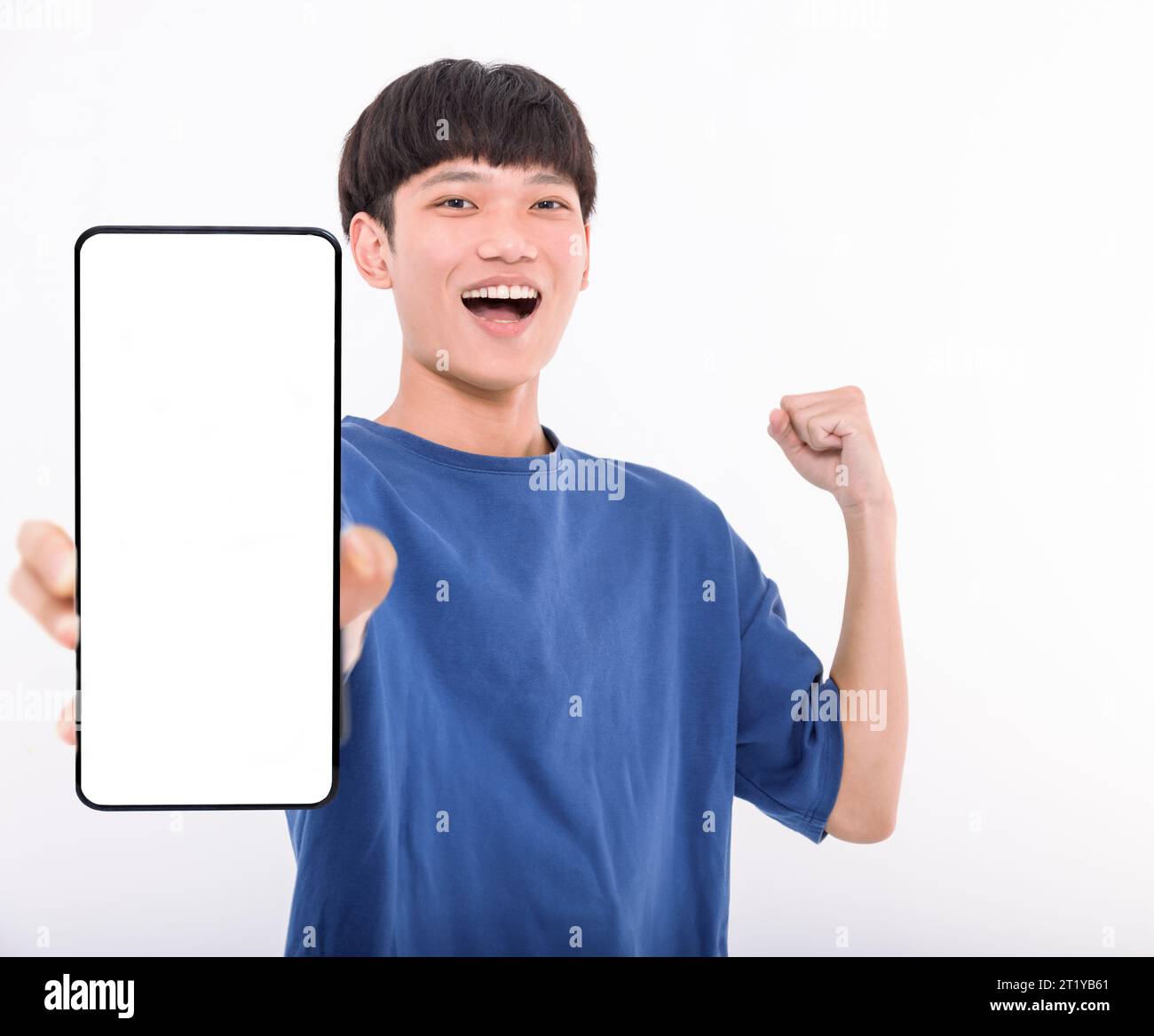 Happy Asian teenaher student holding smartphone mockup of blank screen Stock Photo