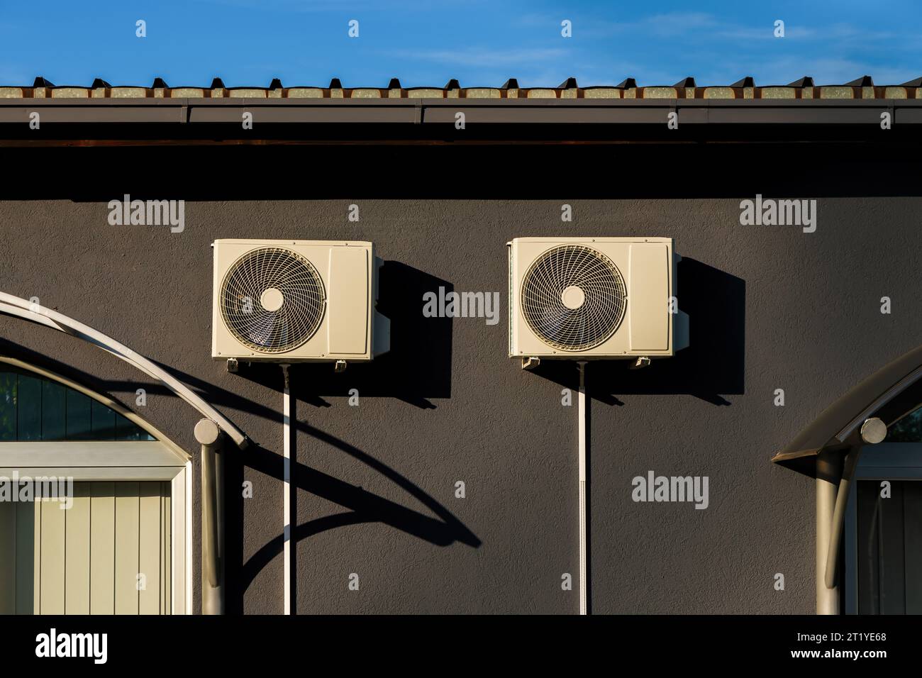 Air conditioner external units mounted on building wall. Heat pumps air to air equipment on facade. Stock Photo
