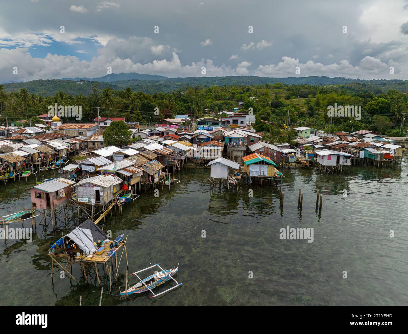 Aerial view boats beside houses located by the water in Zamboanga raised on stilts. Mindanao, Philippines. Stock Photo