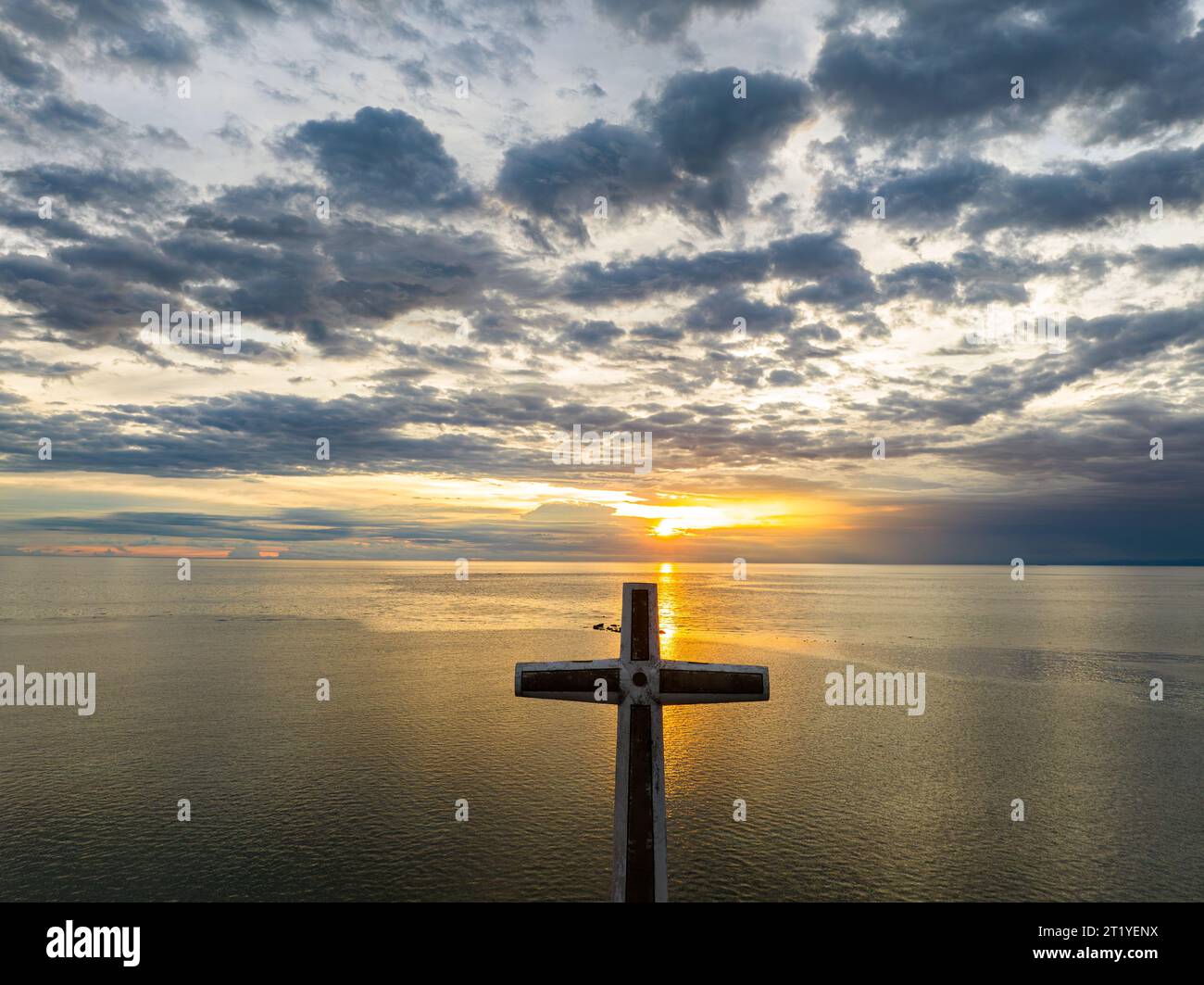 A large cross over the sea in Camiguin Island. Sunset with reflection background. Philippines. Stock Photo