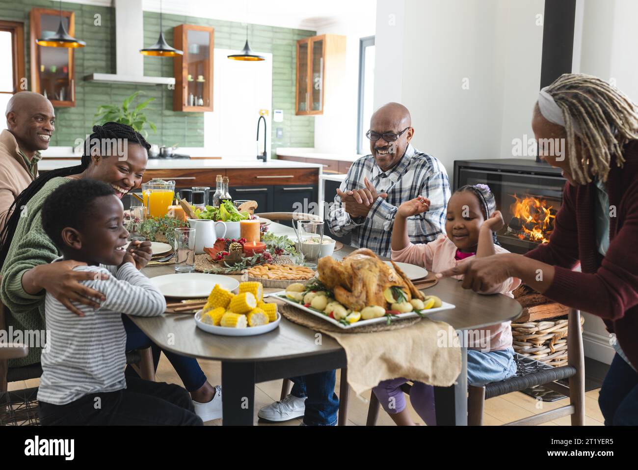 Happy african american multi generation family serving food at thanksgiving dinner Stock Photo