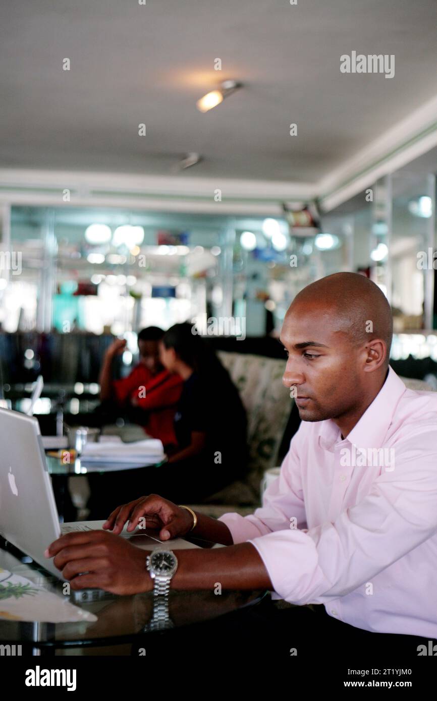 A young Ethiopian business man works on his laptop computer while