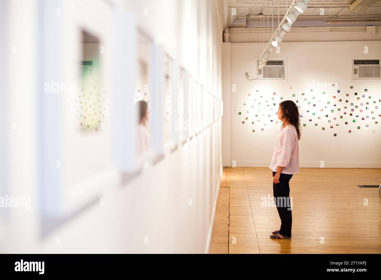 A young woman enjoys an art exhibit in a gallery Stock Photo - Alamy