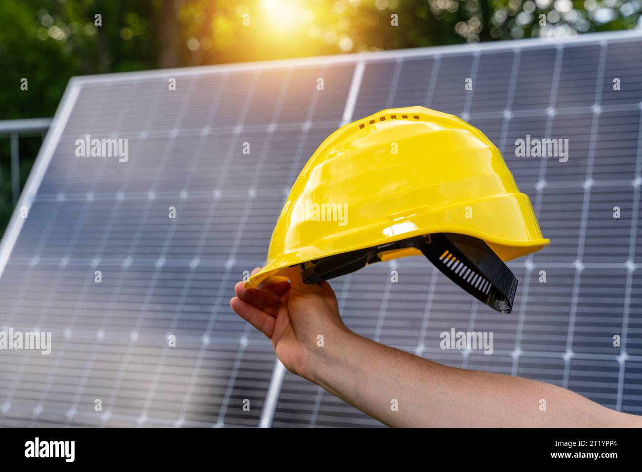 Bavaria, Germany. 12th Aug, 2023. Hand holding a yellow workman s helmet in front of a solar panel. Mounting and building green energy by sunlight *** Hand hält einen gelben Handwerker Helm vor eine Solaranlage. Montage und Aufbau von grüner Energie durch Sonnenlicht Credit: Imago/Alamy Live News Stock Photo