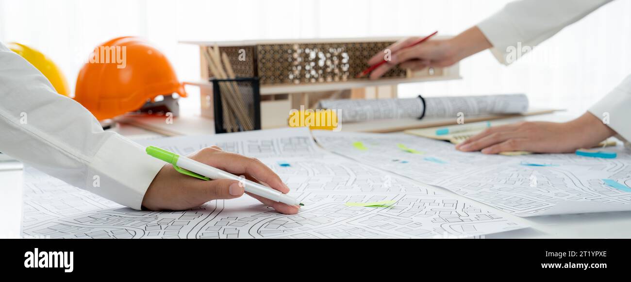 Worker, architect and engineer work on real estate construction project oratory planning with cartography and cadastral map of urban town area to Stock Photo