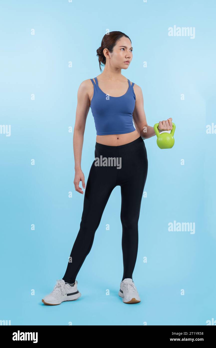 Vigorous energetic woman doing kettlebell weight lifting exercise on