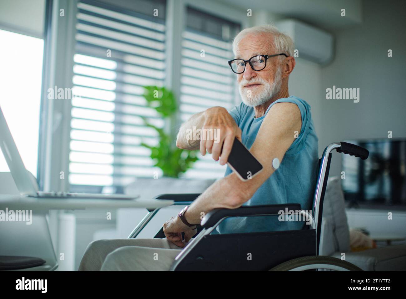 Diabetic senior man checking blood glucose level using continuous