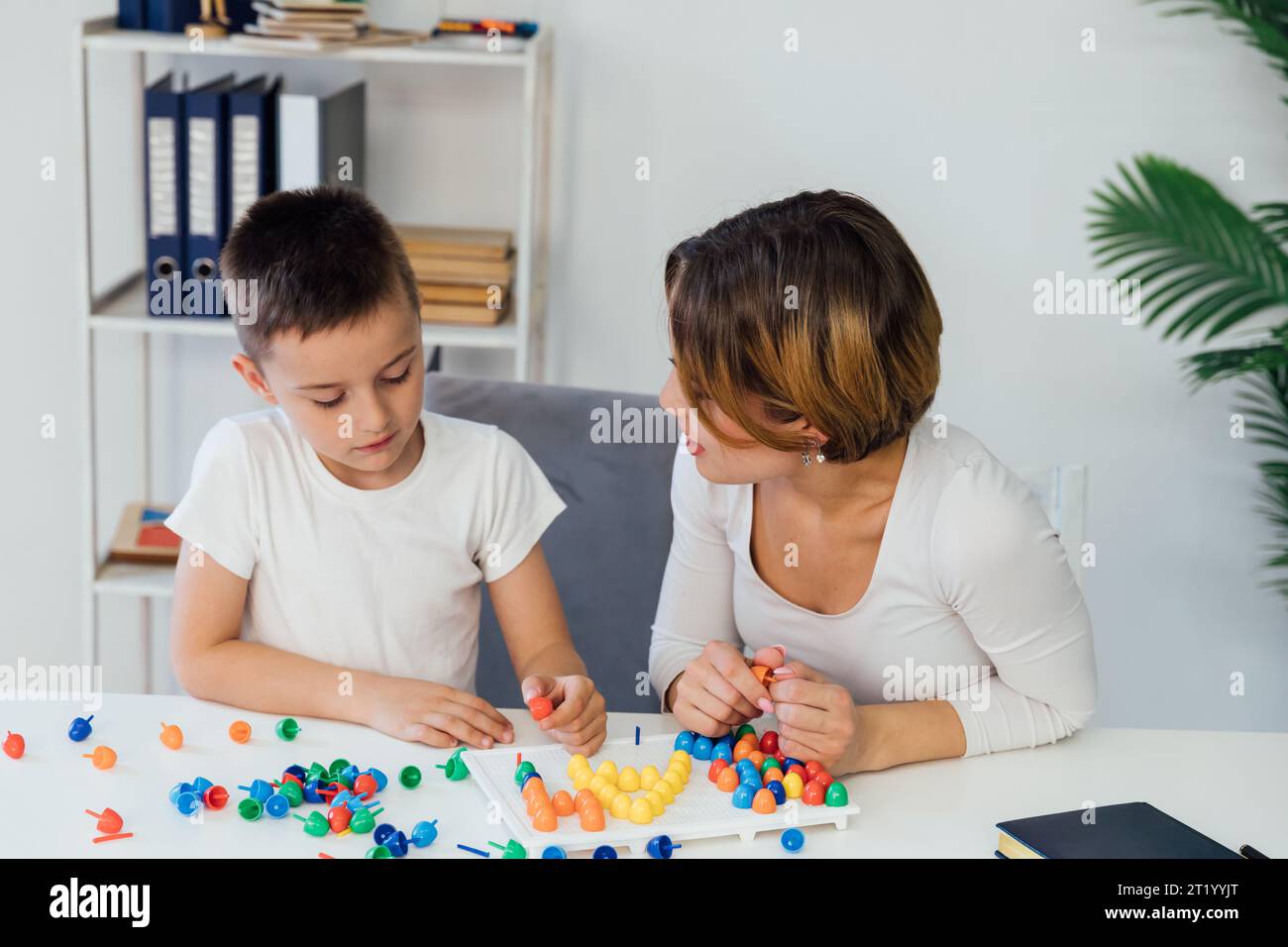 for children a child psychologist is engaged with a boy in the office of educational games Stock Photo