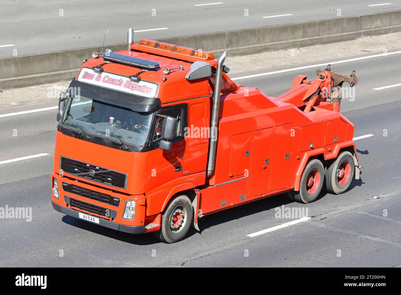 Looking down on clean red unmarked paint on bus & coach Volvo hgv lorry truck a commercial vehicle tow recovery breakdown business on M25 UK motorway Stock Photo