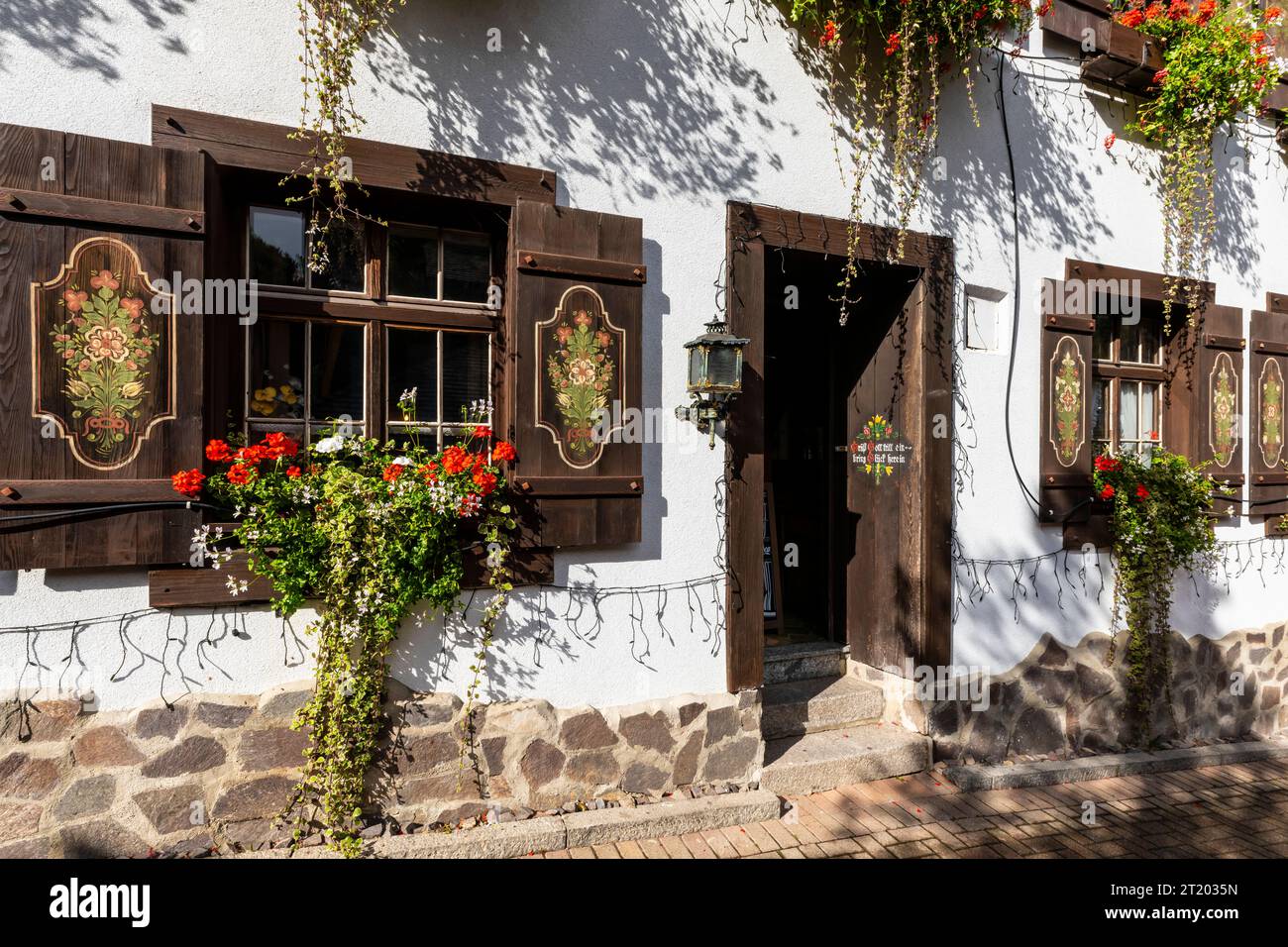 The facade of a traditional building in the Black Forest region with a popular inscription on the door. 'Grüß Gott tritt ein bring Glück herein', whic Stock Photo