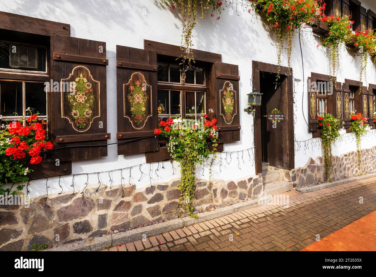 The facade of a traditional building in the Black Forest region with a popular inscription on the door. 'Grüß Gott tritt ein bring Glück herein', whic Stock Photo