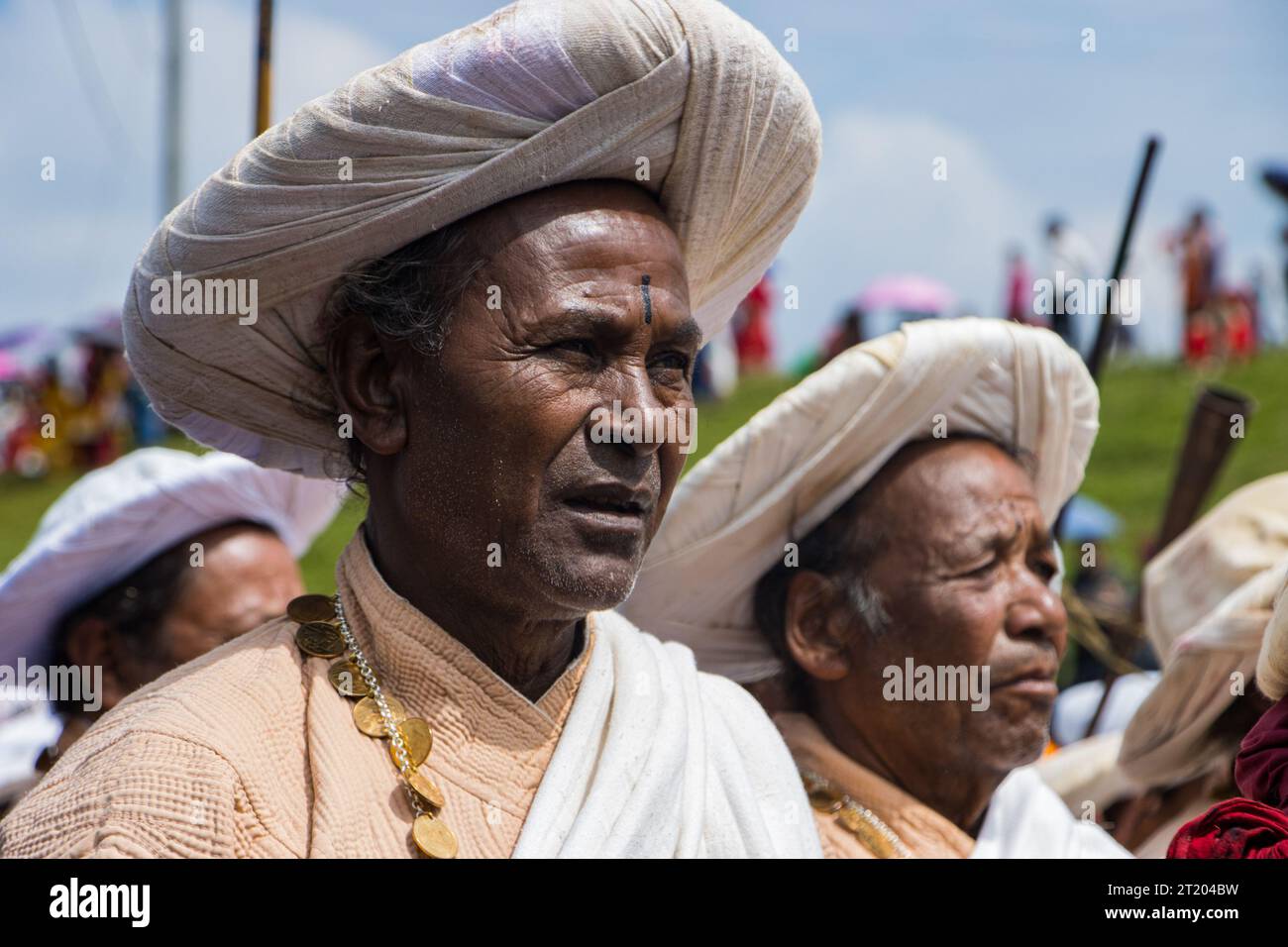 Musicians of Shikhali Jatra wear a saucer hat, beige top and white long skirt secured at the waist by a sash. They wear coin necklaces and play Ponga Stock Photo