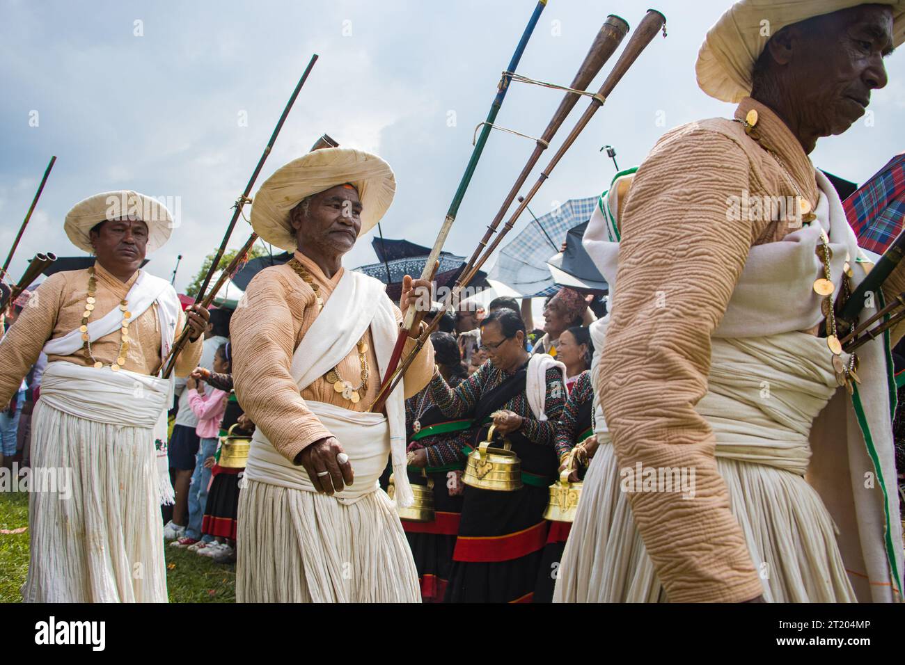 Musicians of Shikhali Jatra wear a saucer hat, beige top and white long skirt secured at the waist by a sash. They wear coin necklaces and play Ponga Stock Photo
