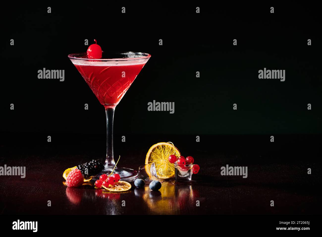 freshening cosmopolitan garnished with cocktail cherry on black background, concept Stock Photo