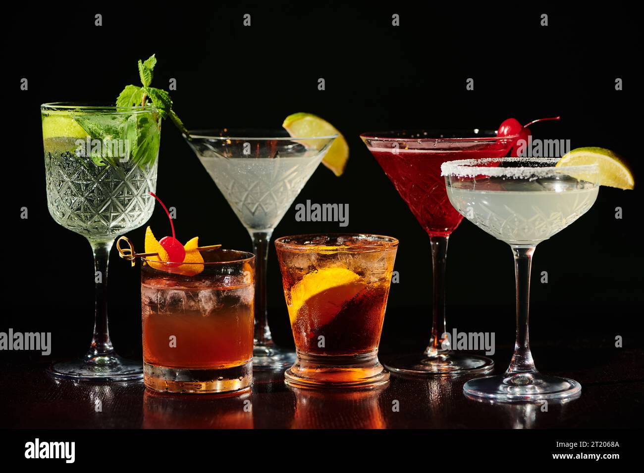 five thirst quenching zesty cocktails with fresh garnishments on black backdrop, concept Stock Photo