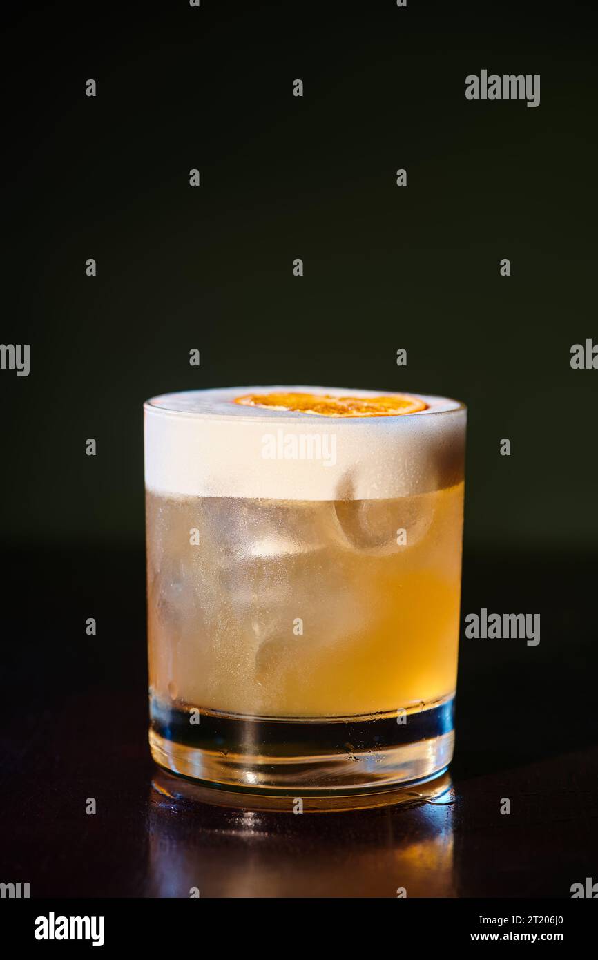 quenching refreshing whiskey sour with delicious frothy foam on black