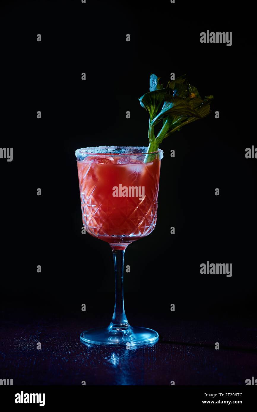 refreshing bloody mary cocktail with ice and celery stalk on black