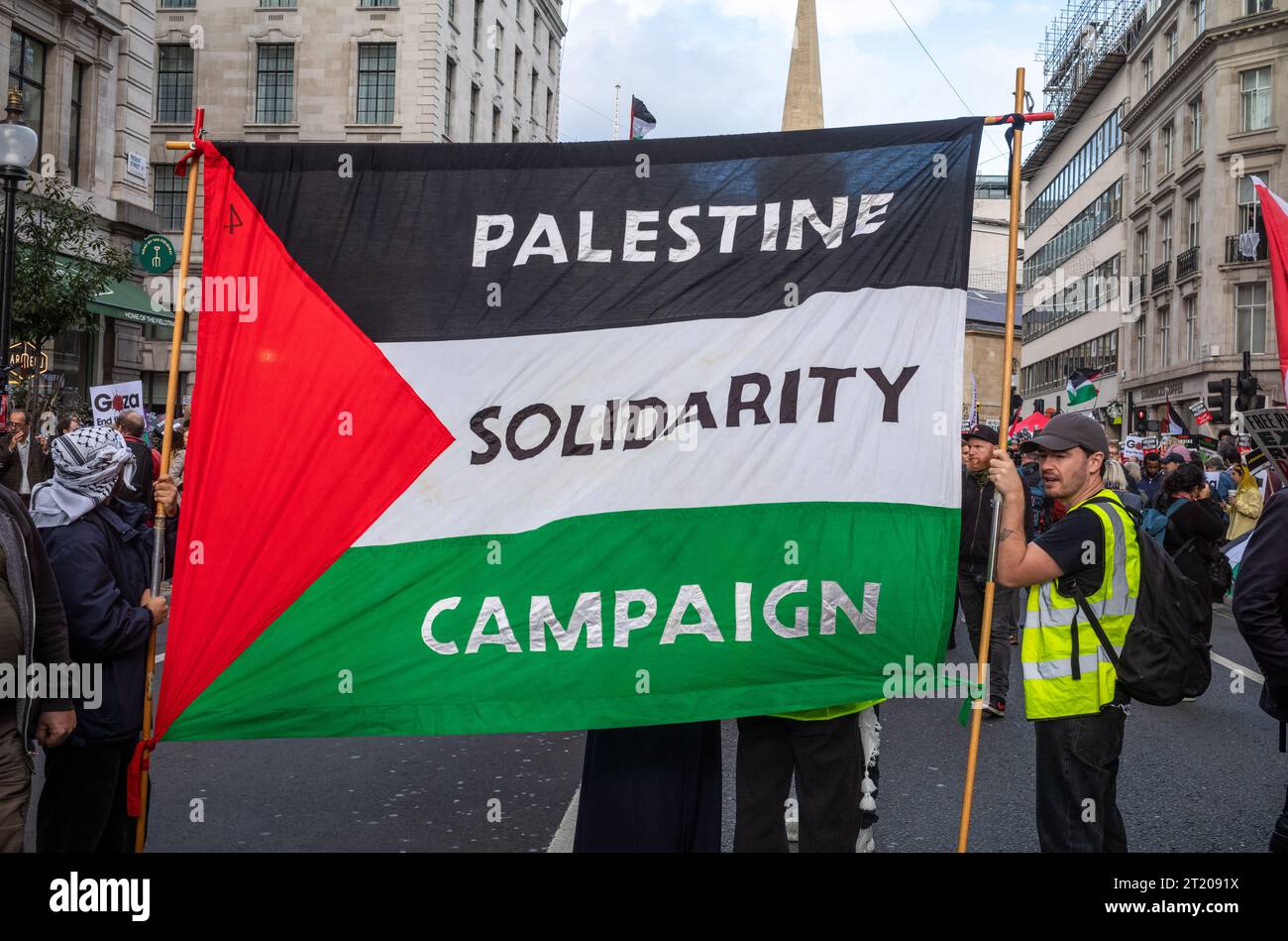 London, UK. 14 Oct 2023: Pro-Palestinian men hold a large Palestinian