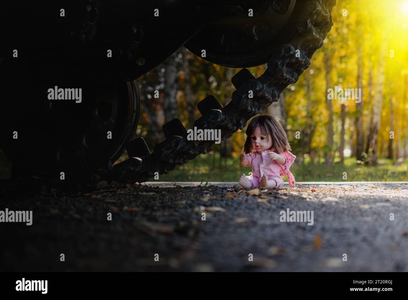 the concept of destroying childhood by war. a frightened doll and tank