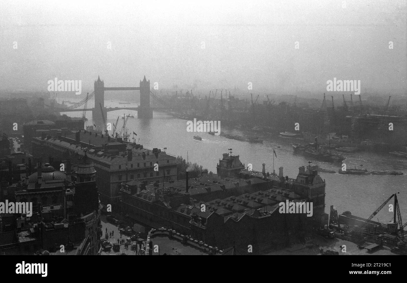 1950s, historical, aerial view  from this ear over the River Thames, showing Tower Bridge, the riverside wharves and skyline of London as seen from Lower Thames St, Billingsgate, London, England, UK. Stock Photo