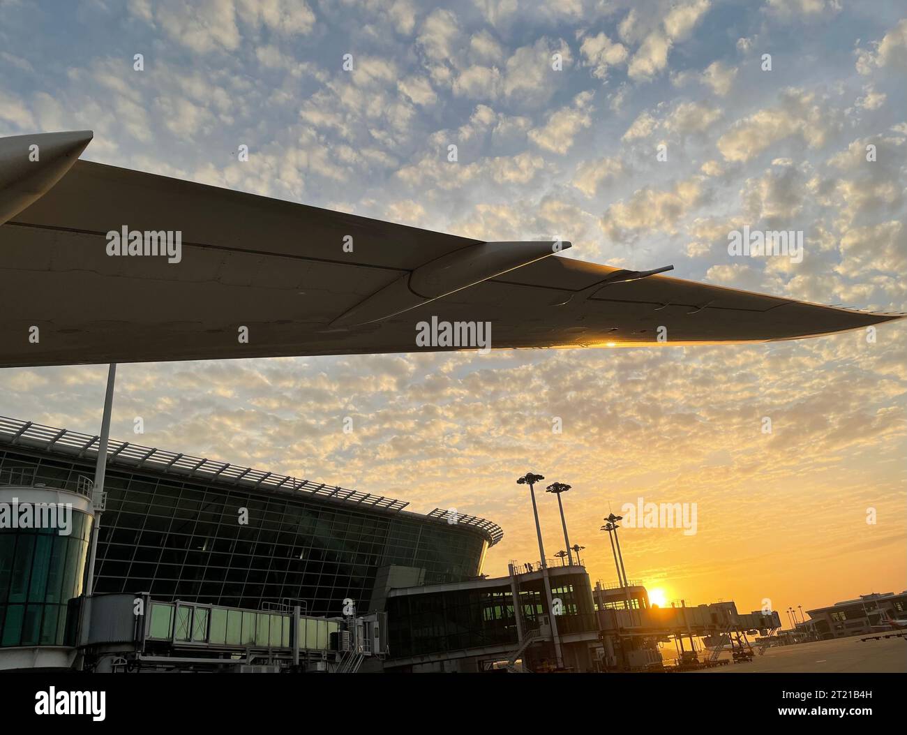 A large passenger jet pictured on the tarmac of an airport at sunset ...