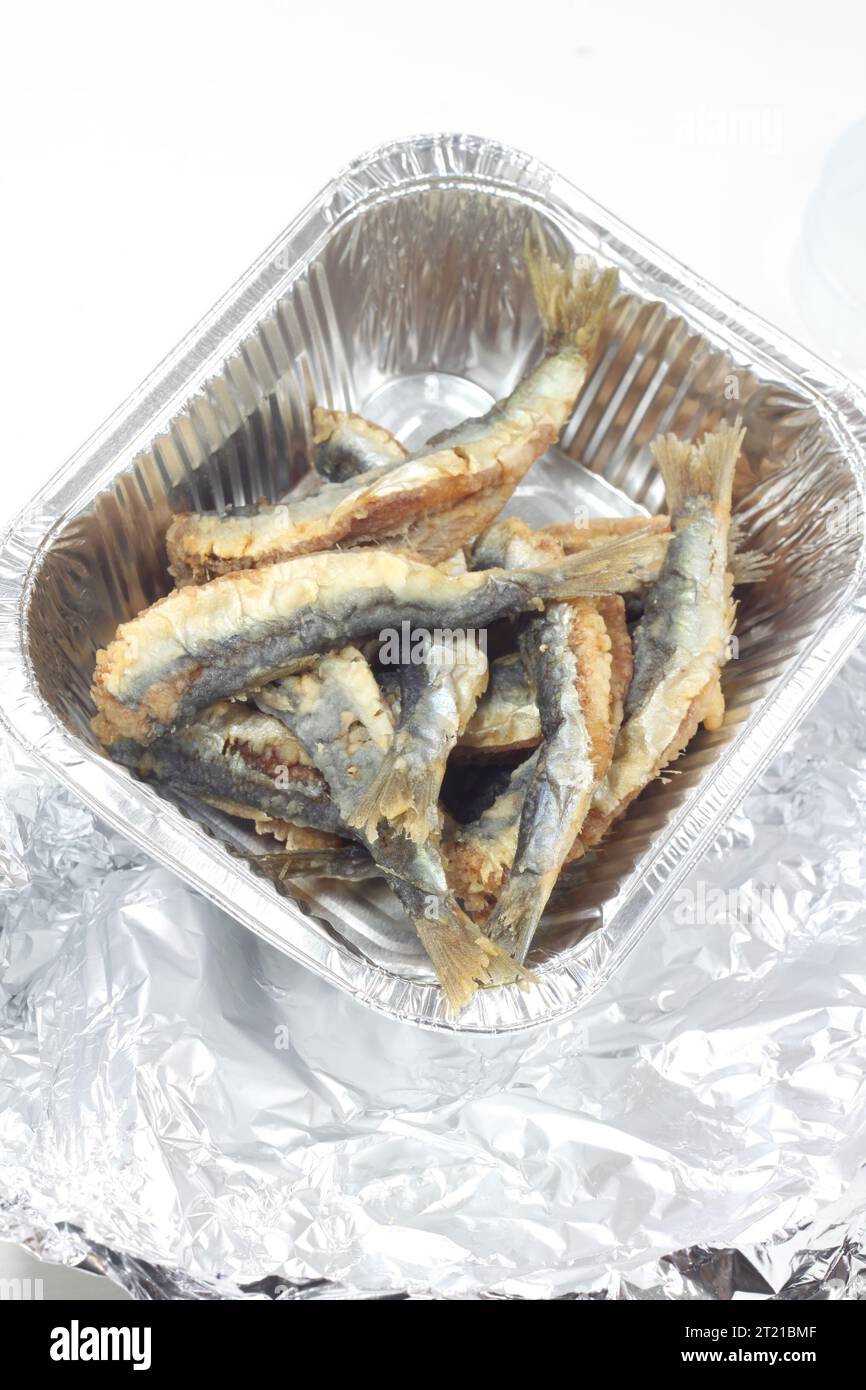 A closeup of fish in a tinfoil container on a white background Stock Photo