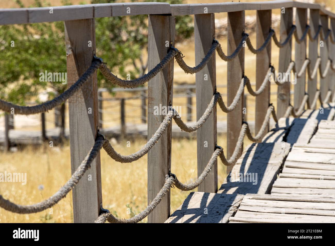 Wooden rope fence railings and field meadow. Sidewalk pathway bridge Stock Photo Alamy