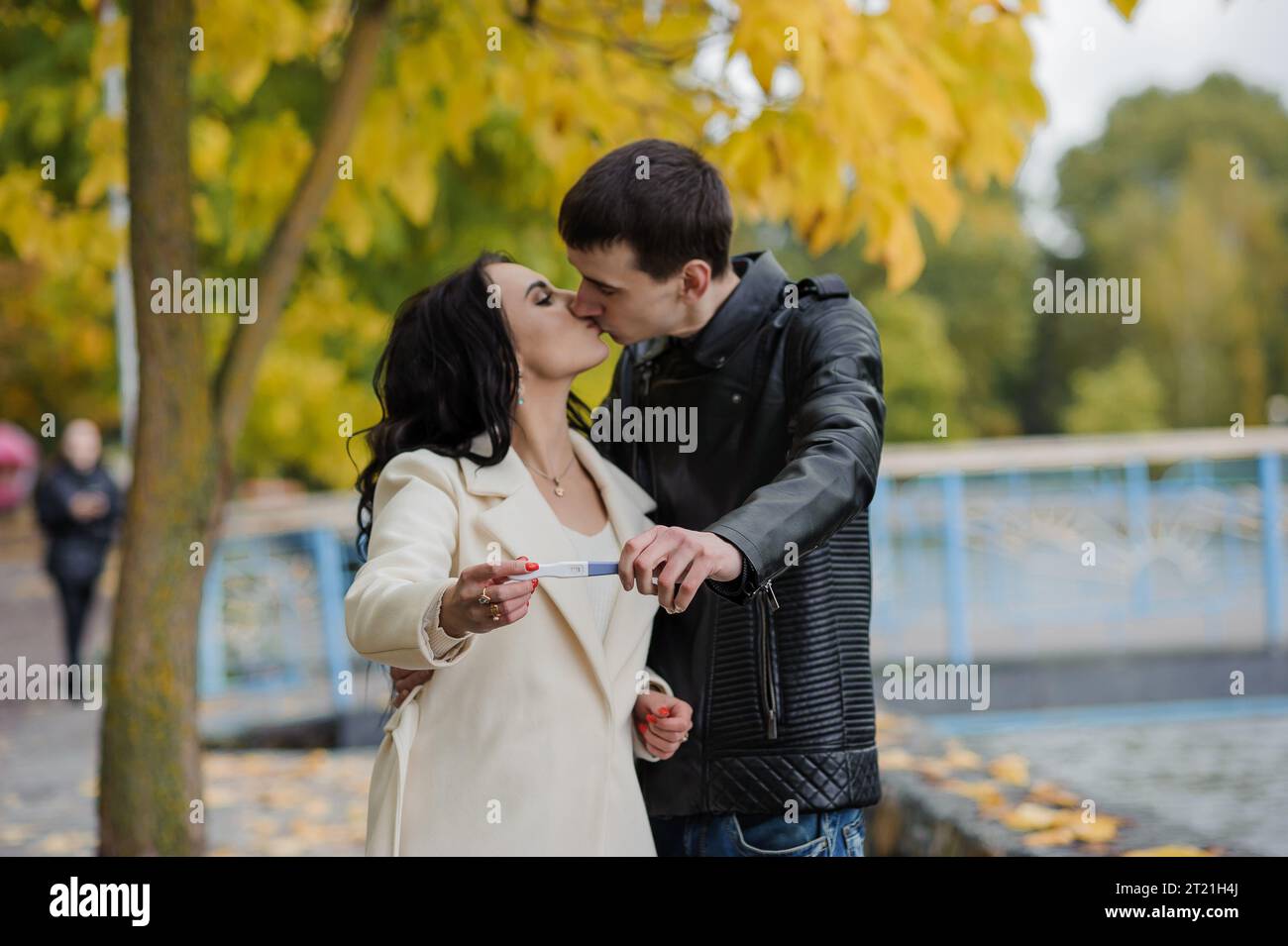 A man hugs his pregnant wife. Woman holding positive pregnancy test ...