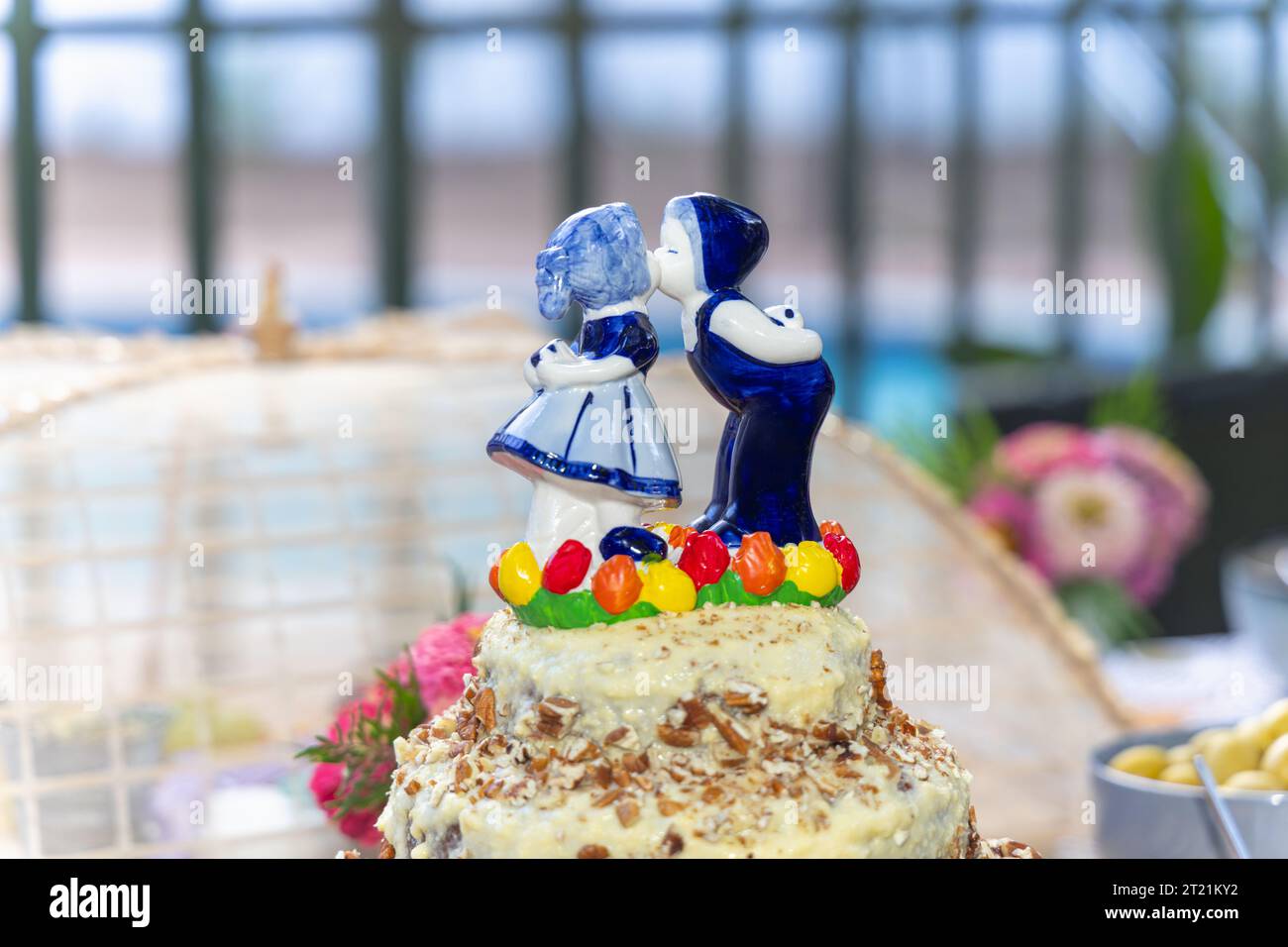 wedding cake and party decorations outdoors, dutch figurine boy and girl kissing blue. Stock Photo