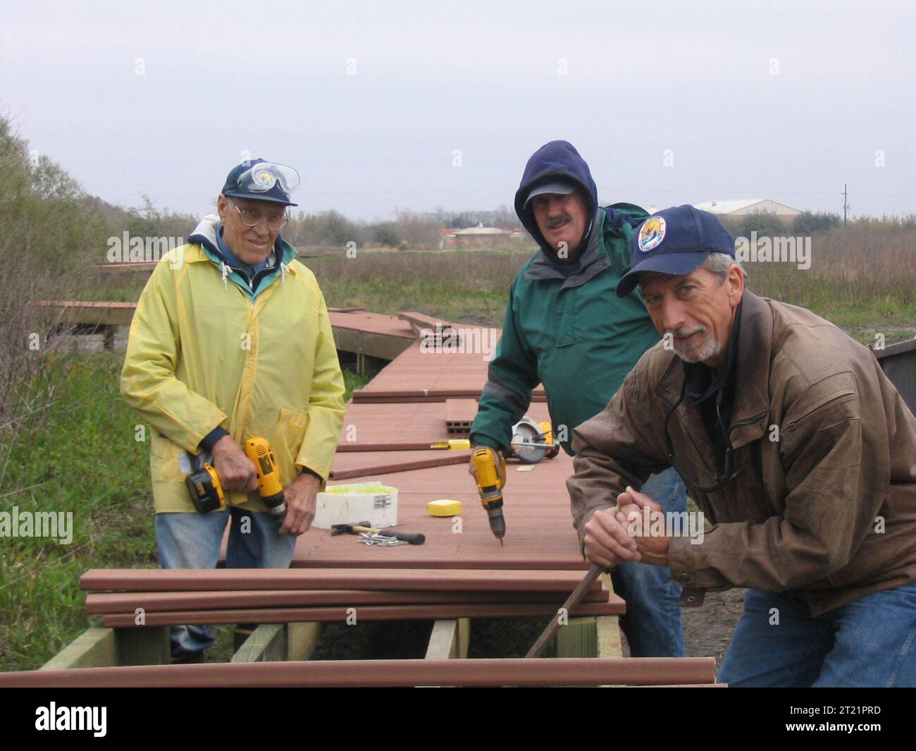 A group of three volunteers have fun creating the new boardwalk for