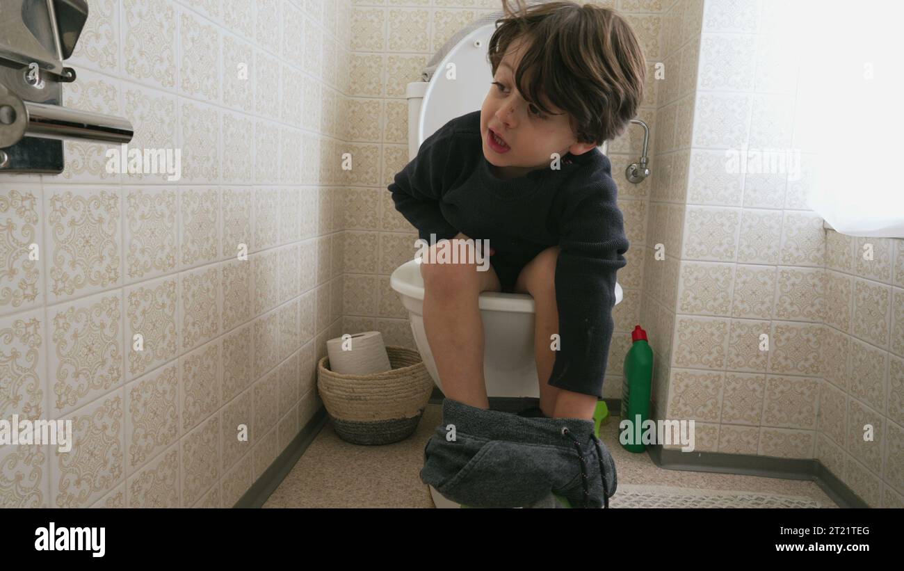 One cute little boy sitting on toilet seat. child doing his hygiene needs Stock Photo