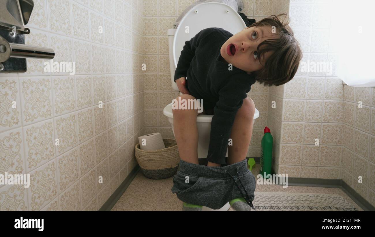 One cute little boy sitting on toilet seat. child doing his hygiene needs Stock Photo