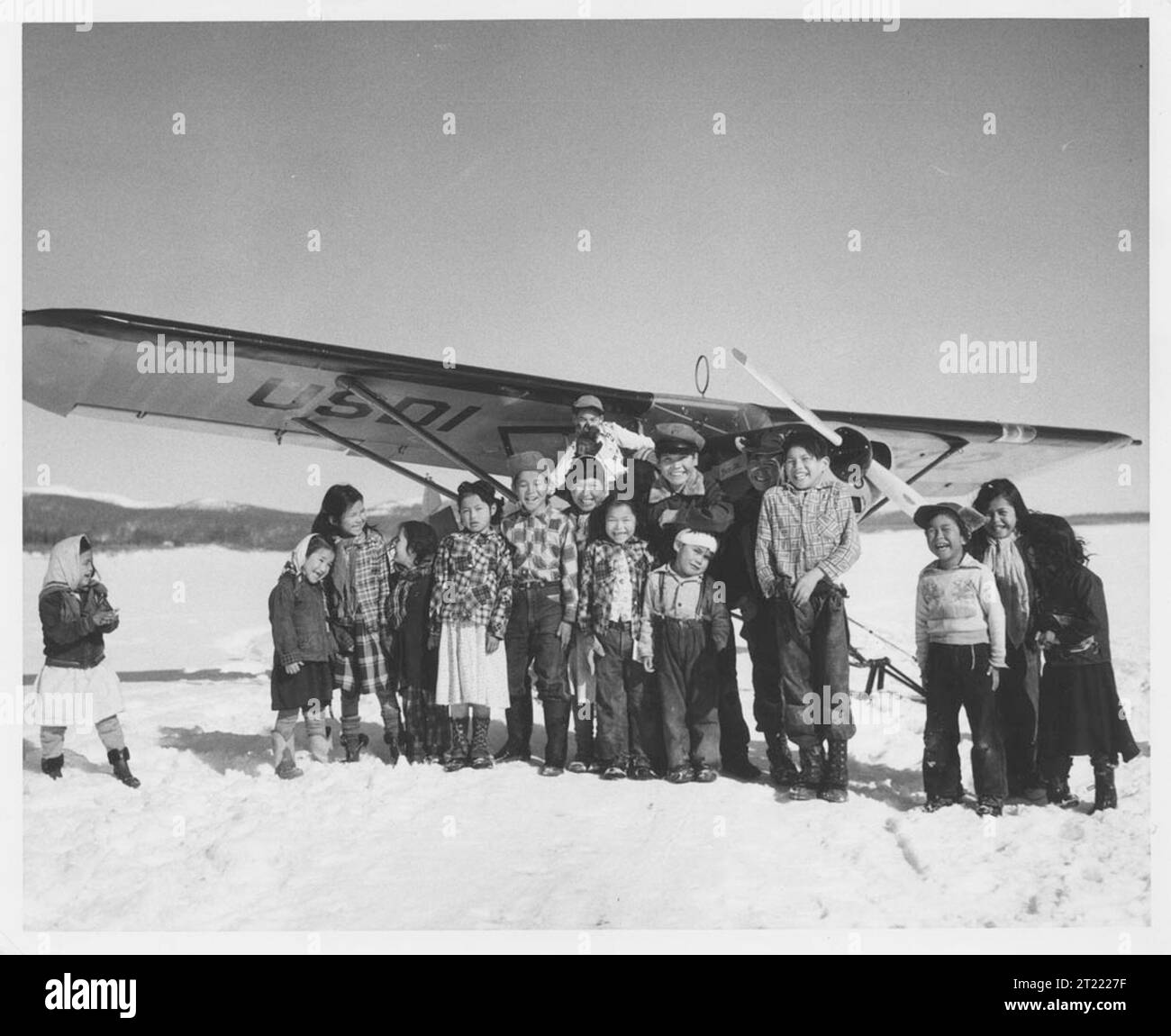 Children in front of small plane on skiis. The village of Kaltag is located on the Yukon River. Subjects: Jim King Collection; Yukon River; Native Americans; Transportation; Aircraft; Aircraft; Alaska.  . 1998 - 2011. Stock Photo