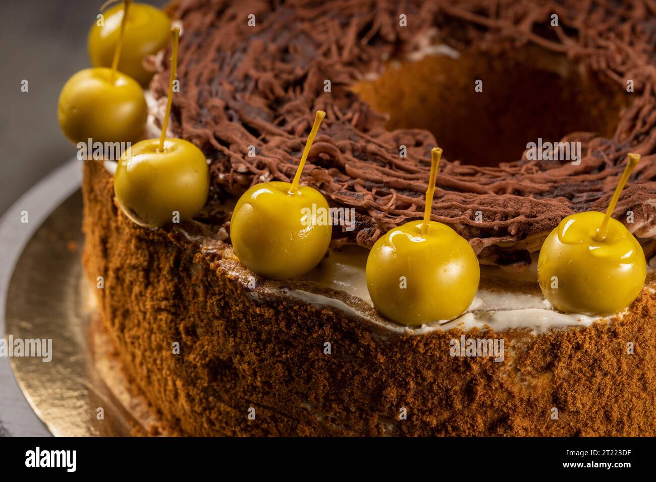 Homemade chocolate cake sweet pastry dessert with brown icing, green decorative cherries. Dark food photo, rustic style. Stock Photo