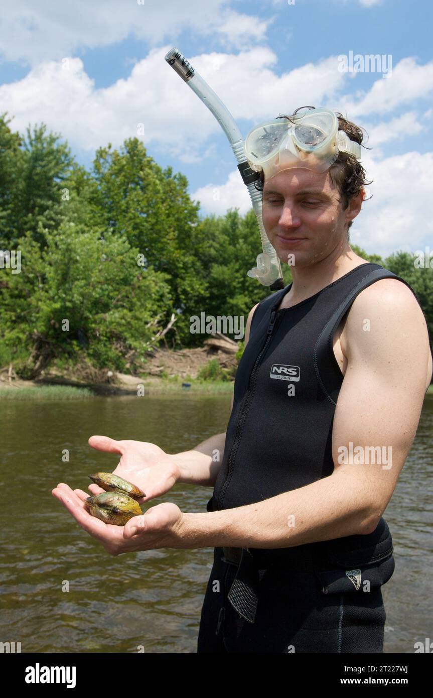 Nathaniel P. Hitt displays freshwater mussels he retrieved from the