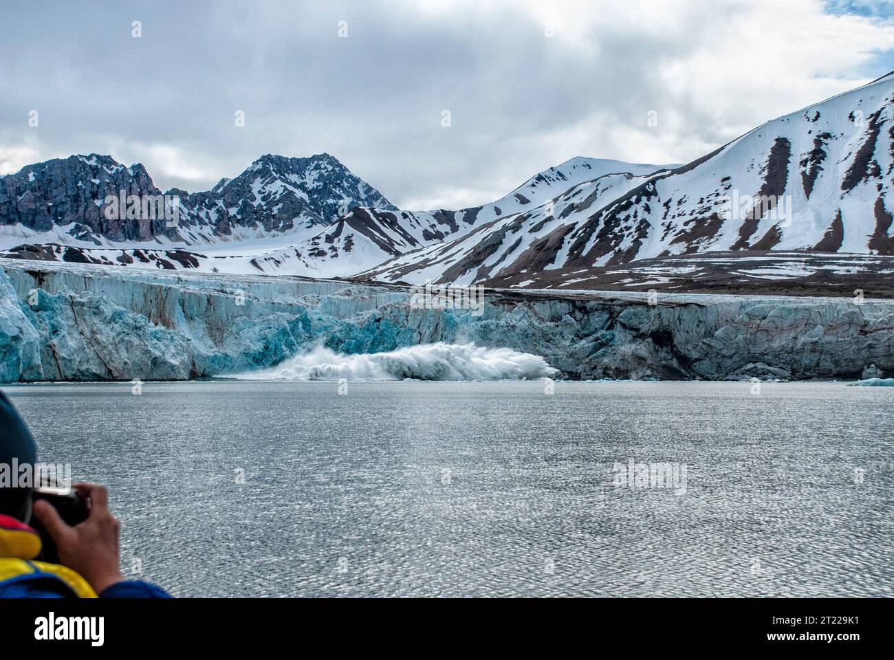 Photographer watching Fjortende Julibreen, 14th July Glacier calving, Svalbard, Norway Stock Photo